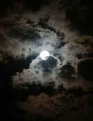 dark sky moon shining through clouds 2 cropped.jpg (90358 bytes)